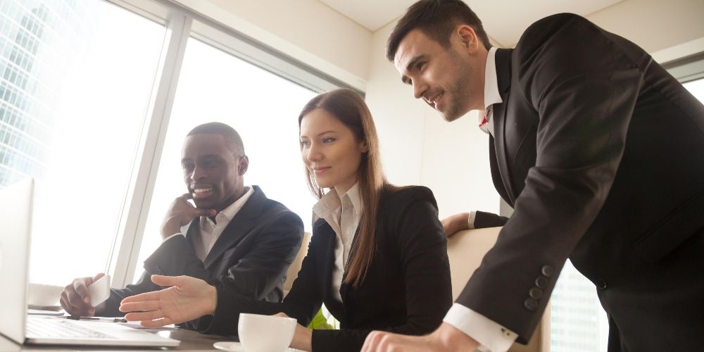 Employees in an office carrying out a remote B2B transaction with a customer using a laptop.